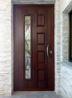 a wooden door with glass paneling on the side and brick wall next to it