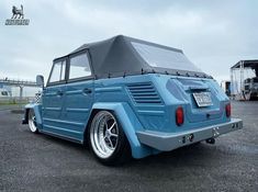 an old blue truck with a tarp on it's roof is parked in a parking lot