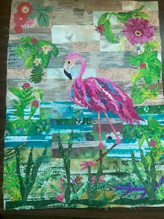 a pink flamingo standing on top of a patchwork piece of paper with flowers and leaves