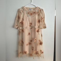 Size Medium Peach Mini Dress With Embroidered Flowers. Comes With Peach Slip, Never Worn- New With Tags! Peach Short Sleeve Dress For Vacation, Short Sleeve Peach Dress For Vacation, Apricot Short Sleeve Dress For Spring, Apricot Short Sleeve Dress For Vacation, Short Sleeve Peach Vacation Dresses, Sheer Short Sleeve Dress For Vacation, Short Sleeve Sheer Dress For Vacation, Sheer Short Sleeve Vacation Dress, Feminine Peach Mini Length Dress