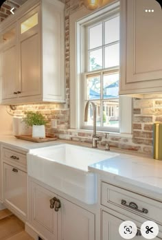 a white kitchen sink sitting under a window