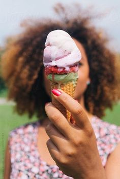 a woman holding an ice cream cone in her hand by jovo studio for stocks