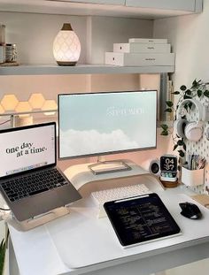 a desk with a laptop, monitor and keyboard on it