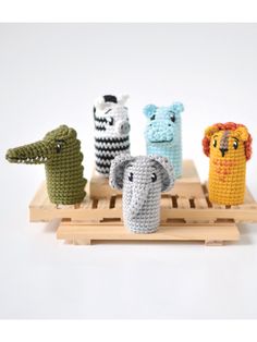 four crocheted animals sitting on top of a wooden tray