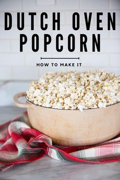 a bowl filled with popcorn sitting on top of a counter next to a red and white towel