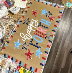 a large birthday cake on top of a table with confetti and candy around it