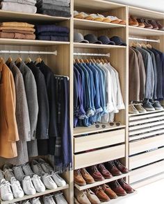 a closet filled with lots of different types of shoes and clothing hanging on wooden shelves