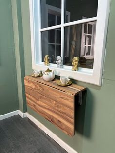 two bowls are sitting on a wooden cabinet in front of a window with green walls