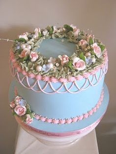 a three tiered cake decorated with flowers and ribbons