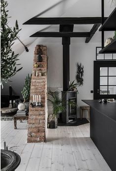 a living room filled with furniture and a fire place next to a brick oven on top of a wooden floor