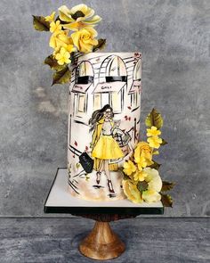 a cake decorated with yellow flowers and an image of a woman in a yellow dress