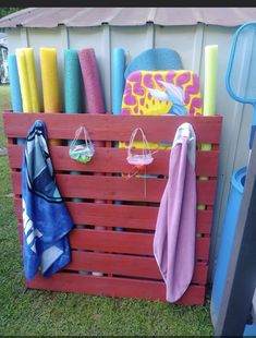 a wooden crate filled with lots of different colored towels and other items on the grass