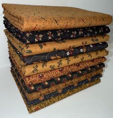 a stack of different types of fabric on top of each other in various sizes and colors