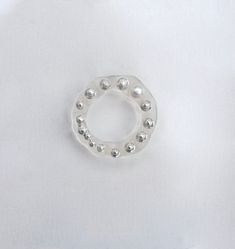 a ring made out of silver balls on a white surface