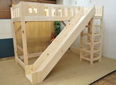 a child's wooden bunk bed with a slide on the bottom and stairs to the top