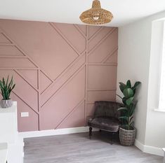 a living room with pink walls and wood paneling on the wall, potted plants in front of it