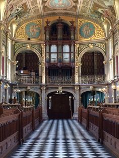 the inside of an old church with ornately decorated pews