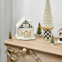 christmas decorations are displayed on a dresser in the living room, including small houses and trees