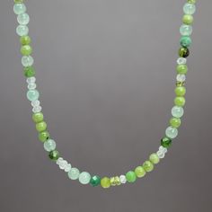 "An array of dainty Jade, Aventurine, Chrysoprase and faceted Idocrase and Prasiolite gems form this beautiful necklace.  These soft shades of pale green are perfect for spring and summer!  28 inches long and fastens with a simple sterling silver lobster clasp.  Genuine 2mm and 3mm facted Idocrase and Prasiolite Genuine 4mm Nephrite Jade, Aventurine, and Chrysoprase 925 Sterling Silver Findings 28\" Long Artisan made in Texas, USA Arrives thoughtfully packaged in a signature kraft jewelry box" Green Jade Stone Necklaces, Green Jade Necklaces With Stones, Green Onyx Necklace With Faceted Beads, Green Necklaces With Round Beaded Stones, Green Emerald Necklace For Jewelry Making, Green Gemstone Beads Crystal Necklace For Healing, Spiritual Chrysoprase Gemstone Necklaces, Adjustable Green Gemstone Crystal Necklace, Green Rondelle Gemstone Beads