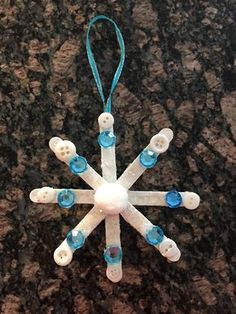 a snowflake ornament with blue and white beads