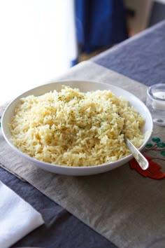 a white bowl filled with rice sitting on top of a table next to a jar