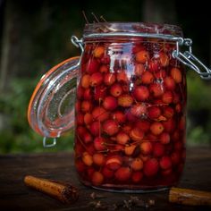 a glass jar filled with lots of red berries