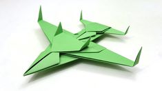 an origami fighter jet is shown in green