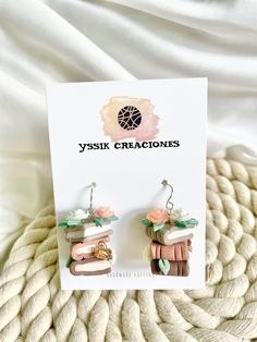 the earrings are made from polymer and have pink flowers on them, with green leaves