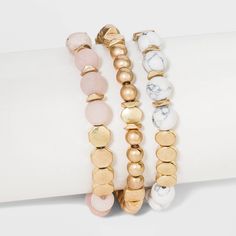 The Semiprecious White Howlite & Sunstone Stretch Bracelet Set from Universal Thread™ makes a statement piece in your jewelry collection. This stylish stretch bracelet set includes two bracelets with round, semiprecious white howlite and sunstone beads that create a subtle contrast with flat gold-toned beads for an eye-catching look you're sure to love, and one bracelet with round and flat worn gold beads that adds a touch of shine to your outfit. Whether worn separately or together, this worn g Cheap Gold Stretch Bracelet With Spiritual Style, Cheap White Stretch Bracelet With Gold Beads, Gold Stretch Bracelet With Round Beads For Beach, Gold Spiritual Stretch Bracelet For Beach, Bohemian Gold Stretch Bracelet With Wooden Beads, Gold Stretch Bracelet, Wood Bead Bracelet, Multi Strand Bracelet, Beads Bracelet Design