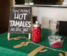 a sign that says how many hot tamales in the jar? on a table