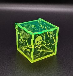 a green cube with skulls and bones on it sitting on top of a black table