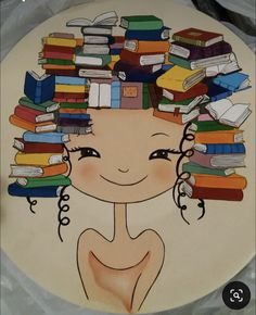 a cake decorated with books on top of it and a woman's face surrounded by stacks of books