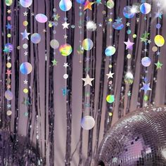 disco balls and stars are hanging from the ceiling in front of a mirror ball curtain