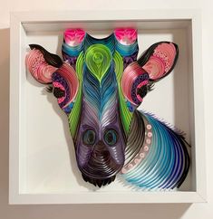 an animal made out of colored paper in a white frame