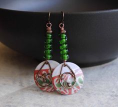 A different twist to your usual holiday earrings featuring green and reddish coral enamel charms. The abstract pattern on the enamels reminds me of a tree branch. I have paired them with spiraling green lampwork beads and copper beads. I have accented them with teardrop shaped copper components. These unique earrings measure 2 1/2 inches in total length and hang on niobium earring hooks. All pieces come boxed ready for gift giving or keeping for yourself. Return to shop: bstrung.etsy.com More li Bohemian Green Jewelry For Holiday, Green Spiral Earrings As Gift, Blue And White Earrings, Lampwork Bead Earrings, Bohemian Christmas, Black And White Earrings, Boho Chic Earrings, Lampwork Earring, Holiday Earrings