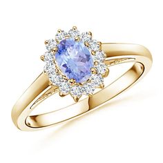 a tan and yellow gold ring with an oval blue sapphire surrounded by diamonds