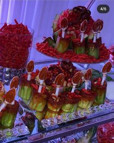 there are many desserts on display in the glass case at this wedding reception, including cucumbers and strawberries