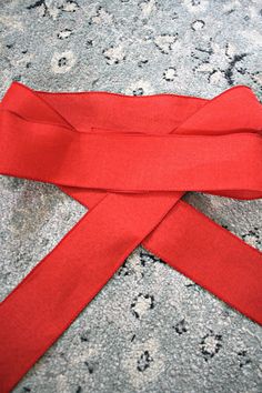 a red ribbon laying on top of a carpet