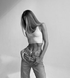 black and white photograph of a woman in high waist jeans with her hands on her hips