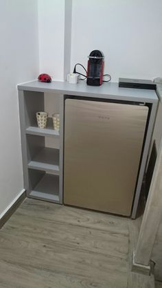 a small kitchen with a metallic refrigerator freezer next to an open shelf on the wall