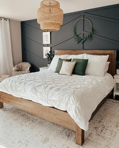 a bed with white sheets and pillows on top of it in a room that has black walls