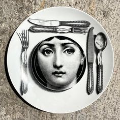 a plate with an image of a woman's face surrounded by utensils