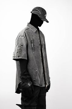 The Distressed Spliced Denim Half-Shirt redefines urban craftsmanship with its unique design and rugged aesthetic. This piece features zipper pockets on the chest and sleeves, adding a functional edge to its streetwear appeal. The shirt has undergone a washing process for a distressed, vintage look that embodies an effortless cool. Arc-shaped splicing and a curved hemline enhance its distinctive style, while the short sleeves make it ideal for layering or wearing alone in warmer weather. Crafted Edgy Streetwear Tops With Pockets, Edgy Tops With Pockets For Streetwear, Urban Washed Denim Jacket, Denim Tops With Pockets For Streetwear, Urban Style Washed Black Denim Jacket For Streetwear, Urban Denim Jacket For Outdoors, Rugged Aesthetic, Half Shirt, Half Shirts