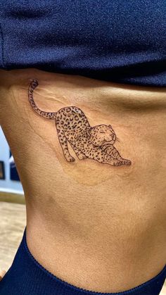 a woman's stomach with a tattoo of a cheetah on the side