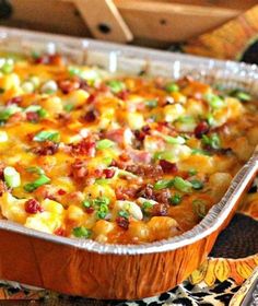 a casserole dish with bacon, cheese and green onions in it on a table