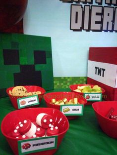 some red bowls filled with food on top of a green cloth covered table next to a minecraft sign