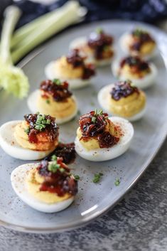 deviled eggs with chili sauce and celery on a plate