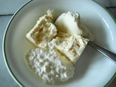 a white plate topped with ice cream next to a spoon