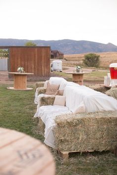 hay covered couches and tables in an outdoor setting