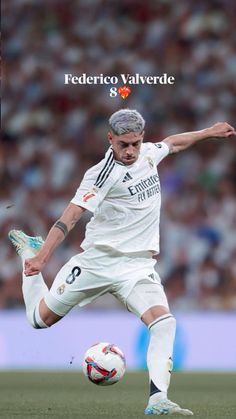 a man kicking a soccer ball on top of a field